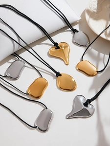 Detailed close-up of 18k gold heart pendants and silver lava charms on black cord necklaces