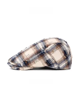 Vue latérale d'une casquette plate à carreaux rétro avec bords effilochés et tweed