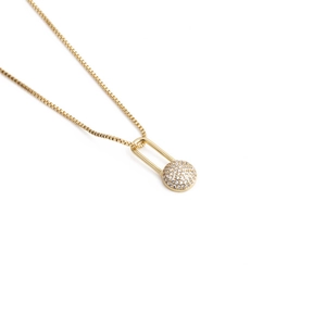 Detailed view of a gold safety pin pendant necklace with a sparkling zircon ball on box chain