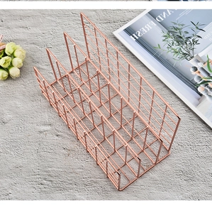 Detailed view of the rose gold metal desk organizer with three vertical compartments