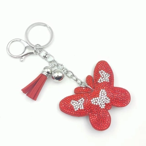 Detail of red rhinestone butterfly keychain with matching tassel and silver metal ball