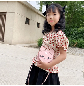 Pink PU leather cat shaped crossbody bag for kids worn by a little girl outdoors