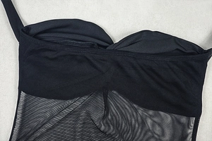 Close-up of black bodycon dress detailing sheer mesh panels and seamless stitching