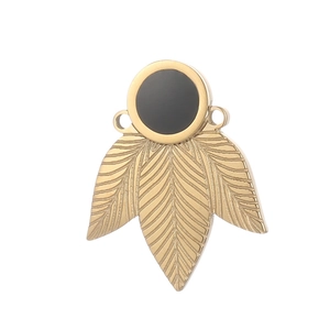 Golden stainless steel clover pendant with black gemstone on white background