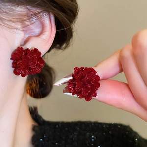Detail of elegant dark red layered flower stud earrings worn by a model for a vintage look