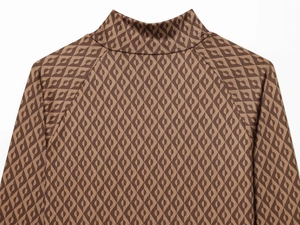 Détail d'un haut en maille marron à motifs losanges avec un col montant élégant