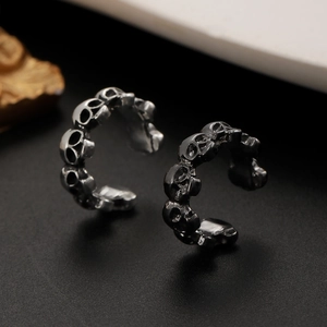 Detailed view of vintage gothic skull ear cuffs in antique silver finish for women