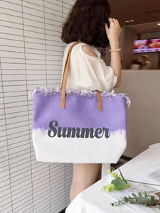Detail der lila gewebten Tragetasche mit Summer-Text und Fransen-Verzierungen