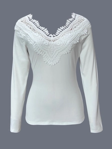 Detailed view of the delicate V-neck lace patchwork on the white long sleeve knit top