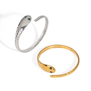 Polished snake wrap bracelets in gold and silver with green gemstone eyes and textured band