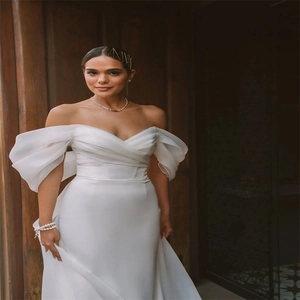 Elegant white off-shoulder satin mermaid wedding dress with dramatic puff sleeves and folds