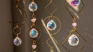 Detailed view of amethyst suncatcher with brass moon and crystals creating rainbow light