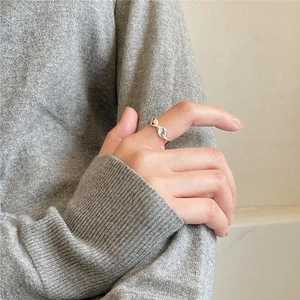 Detail of a 925 sterling silver wavy ring worn on a finger for a minimalist daily look