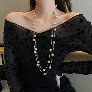 Sautoir multicouche en perles synthétiques et chaîne dorée sur mannequin élégant