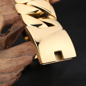 Close-up of a 32mm thick golden stainless steel link bracelet on dark wood background