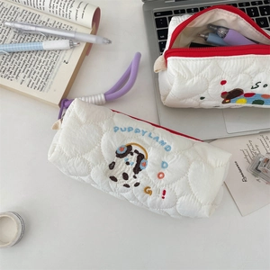 Close-up of quilted pencil case with detailed puppy embroidery and zip closure