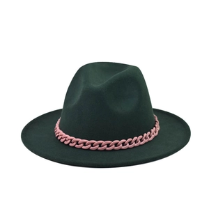 Détail d'un chapeau fedora en laine vert foncé avec chaîne en résine rose contrastante