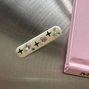Rectangular cream hair clip with colorful faux gems and black star embellishments