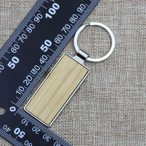 Detail view of rectangular metal and wood keychain with measurement scale reference
