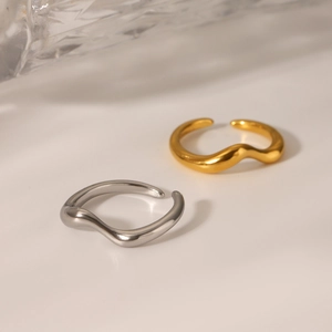 Macro shot of minimalist wavy stainless steel rings in gold and silver finishes