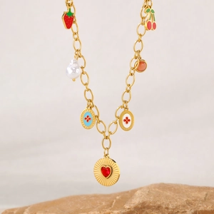 Gold stainless steel necklace with pearl, strawberry, and heart charms on stone base