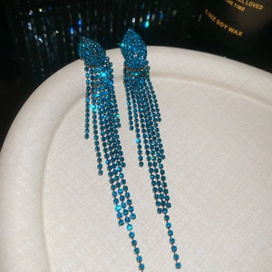 Detail of blue sparkling jellyfish tassel earrings with crystal fringe in a white tray