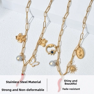 Detail of gold stainless steel paperclip chains with butterfly, star, moon, and pepper charms