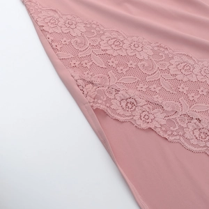 Dettaglio del tessuto in raso rosa con bordo in pizzo floreale su un abito senza schiena