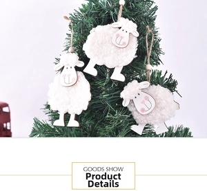Close-up of three cute wool felt sheep ornaments hanging on a green Christmas tree branch
