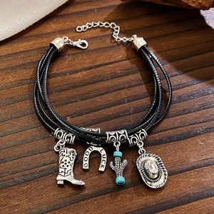 Detail of bohemian layered bracelet with silver cowgirl boot, hat and horseshoe charms