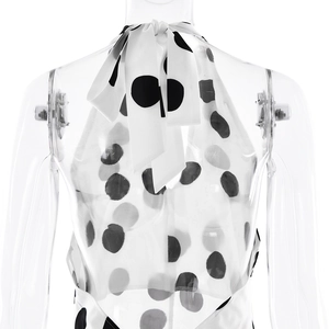 Detailed back view of a white polka dot halter dress featuring a cross-tie back design
