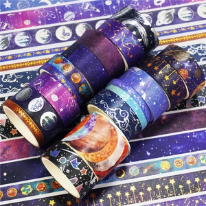 Close-up of starry sky washi tape rolls featuring gold and silver galaxy foil designs