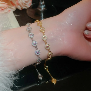 Detailed view of two 18K gold plated zirconia bracelets on a wrist with sparkling lights