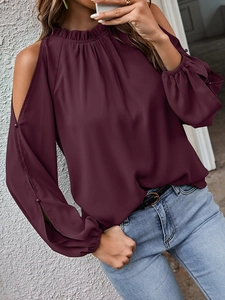 Detailed view of the ruffle high neck and button cuff on wine red cold shoulder blouse