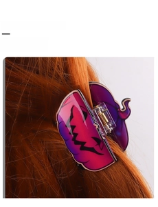 Detail of pink gradient pumpkin hair claw clip styled on bright orange wavy hair