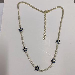 Detail of gold choker with blue zircon flowers and sparkling claw chain link