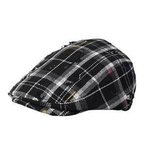 Retro black and white checkered tweed newsboy hat with distressed frayed edges and paint splatters