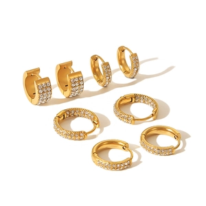 Detail of four pairs of 18k gold plated titanium steel hoop earrings with cubic zirconia