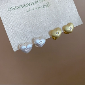 Detailed view of matte heart earrings with star-set zircon on textured display card