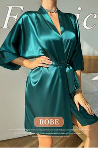 Détail d'un peignoir en satin vert foncé avec ceinture montrant le tissu soyeux