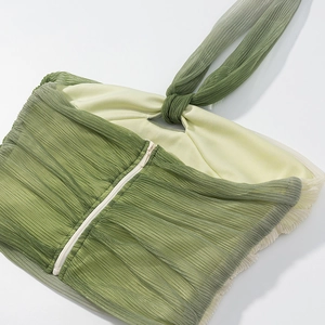 Detail of green gradient pleated fabric top with invisible back zipper and halter tie