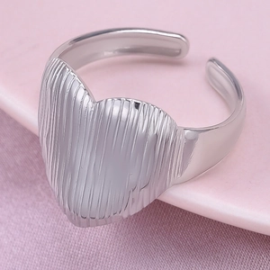 Vue détaillée d'une bague coeur argentée avec texture striée verticale et anneau ajustable