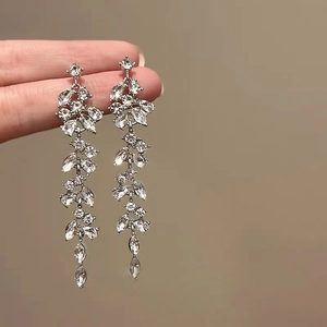 Macro view of silver leaf vine earrings with rhinestones and long tassel chains