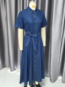 Dettaglio di un abito in denim blu scuro con scollo a V, cintura annodabile e linea ad A