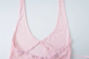Close-up showing the delicate pink lace texture and neck tie detail of the camisole