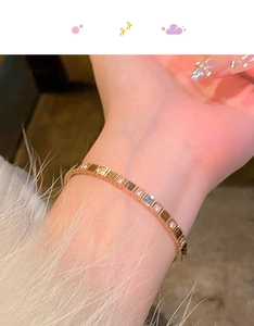 Close-up of rose gold bangle featuring square links and sparkling zircon stones