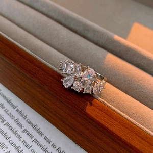 Detailed view of silver open ring with mixed-cut cubic zirconia in a grey velvet jewelry box