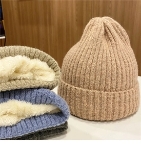Dettaglio di un caldo berretto in maglia con spessa fodera in pile bianco e trama a coste