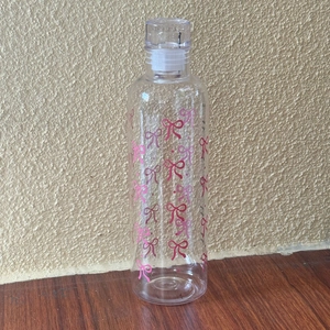 Close-up of heat-resistant plastic bottle with pink bow patterns and clear screw cap