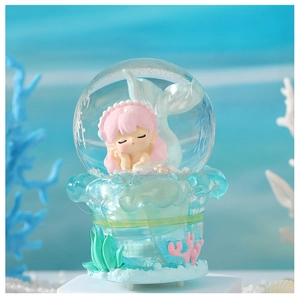 Detailed view of ocean theme mermaid crystal ball with resin pink hair princess and coral décor